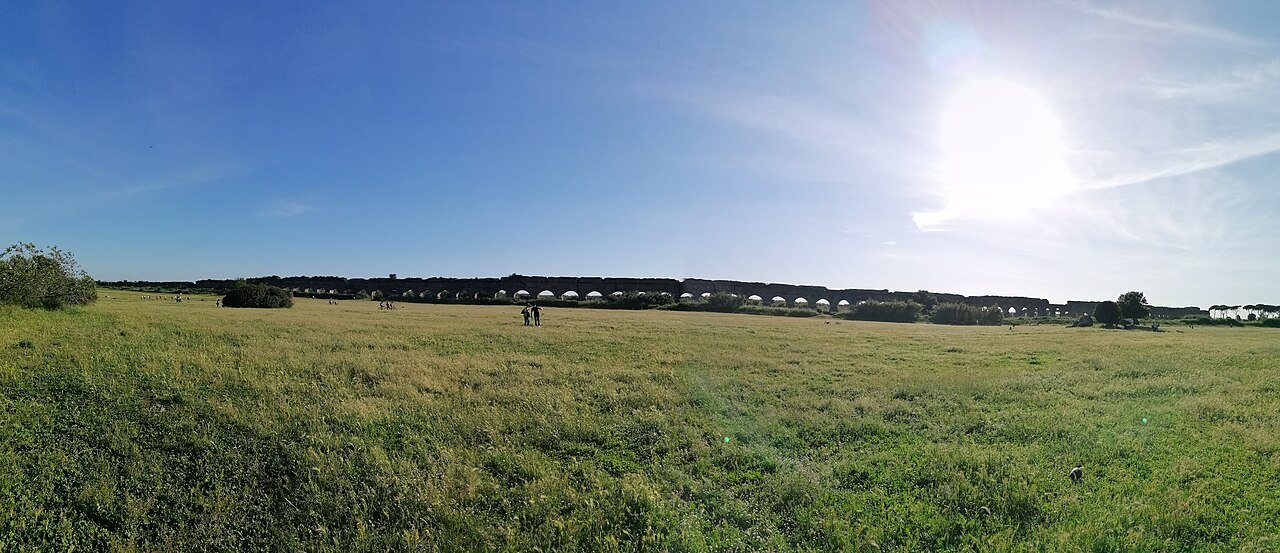 Open grassland in the Park of the Aqueducts, the long line of arches in the distance