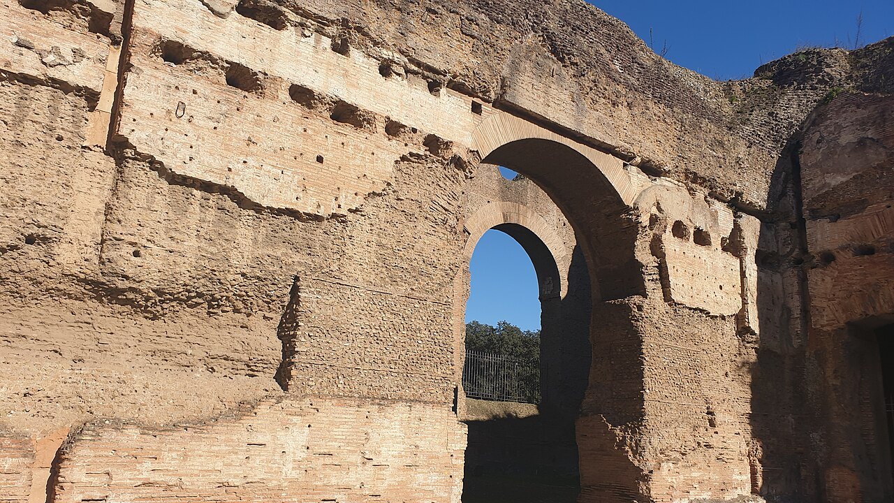A great brick arch in the eastern palaestra of the Baths of Caracalla, the sky showing through it