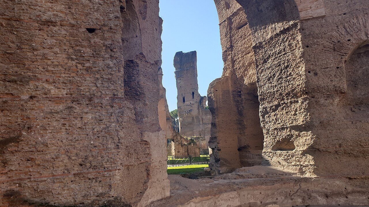 Tall brick walls of the swimming pool at the Baths of Caracalla, the sky between them