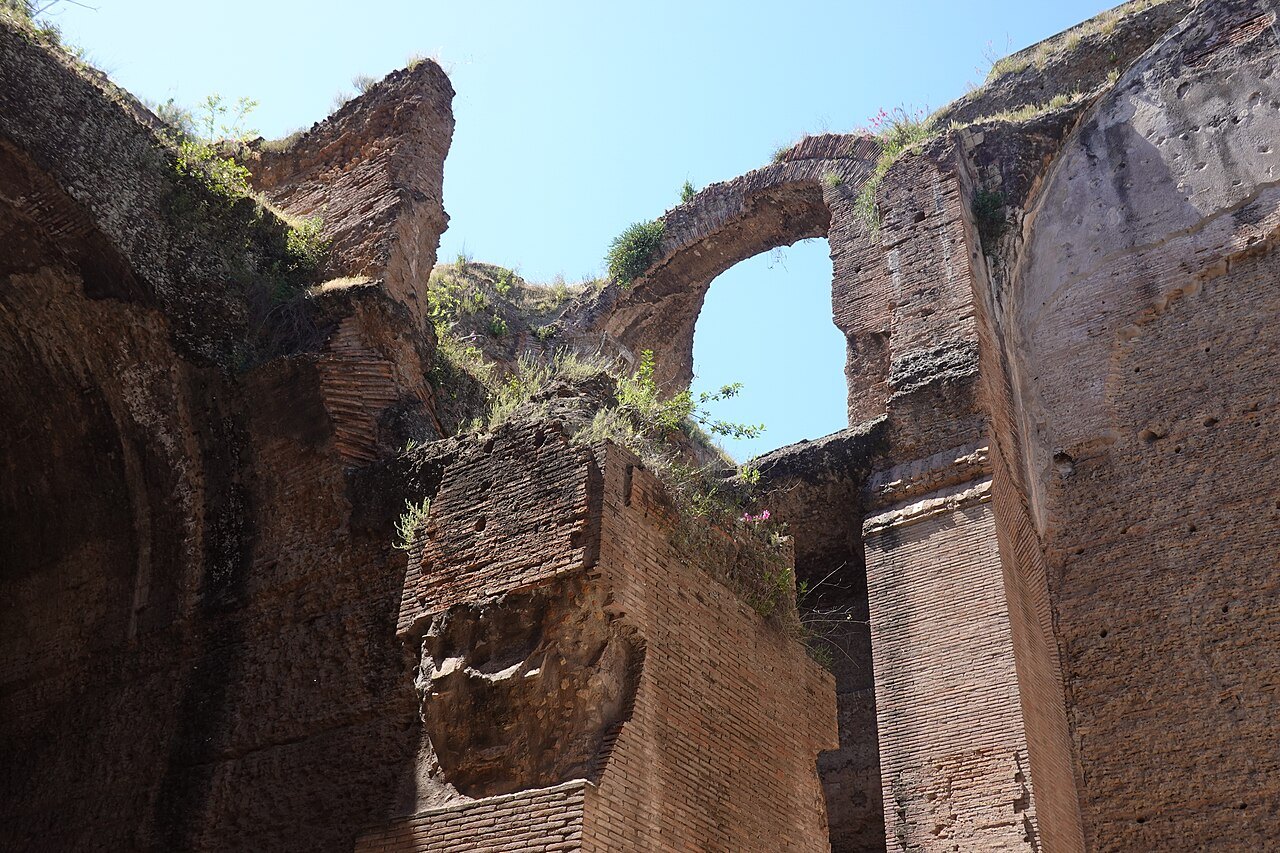 Broken brick vaults and walls of the Baths of Caracalla, grass growing on their tops