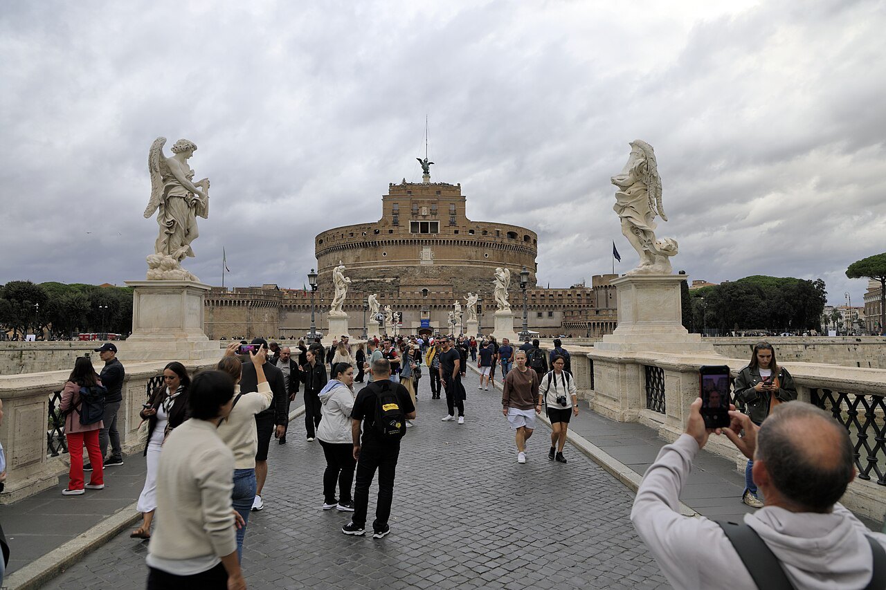 Visitors on the Ponte Sant'Angelo between two angels, Castel Sant'Angelo at the end of the bridge