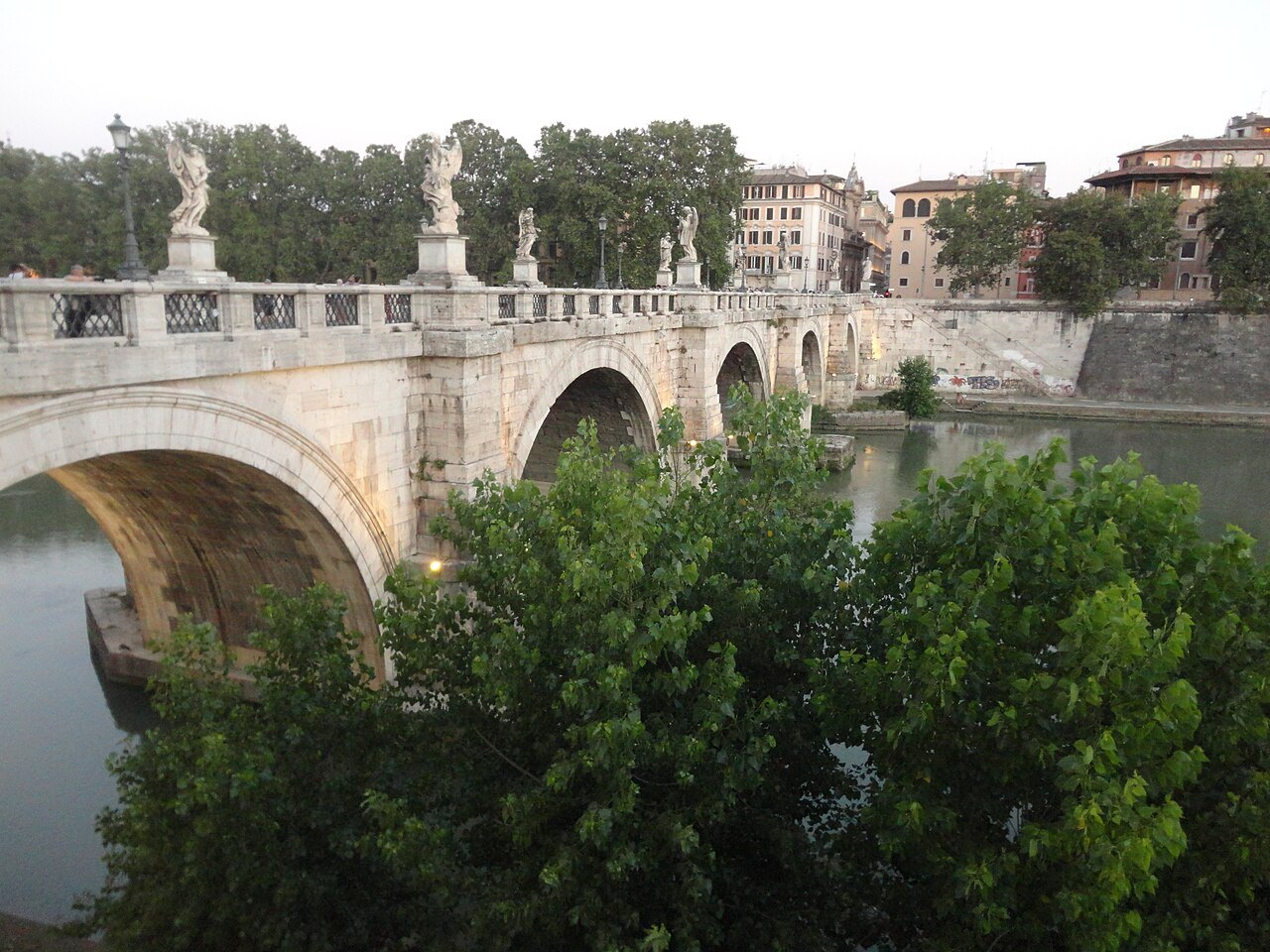 The Ponte Sant'Angelo with its angels over the Tiber, trees on the bank in front
