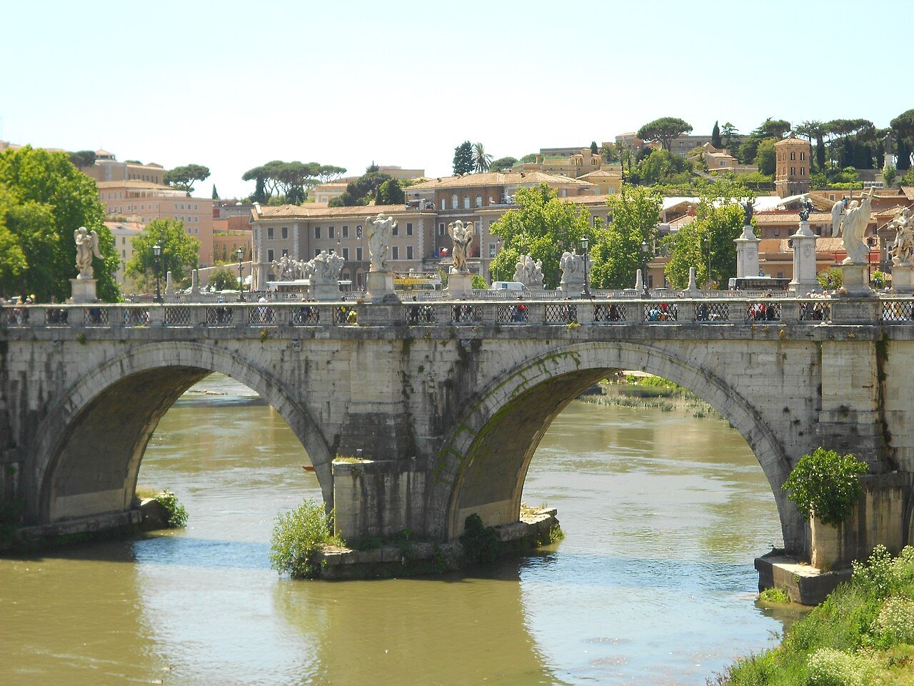 Two arches of the Ponte Sant'Angelo over the green Tiber, statues on the parapet