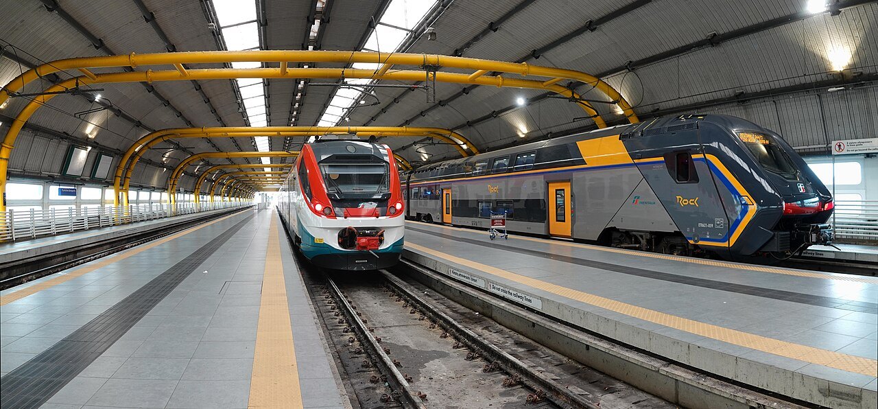 Two trains at the platforms under the steel roof of the Fiumicino airport station