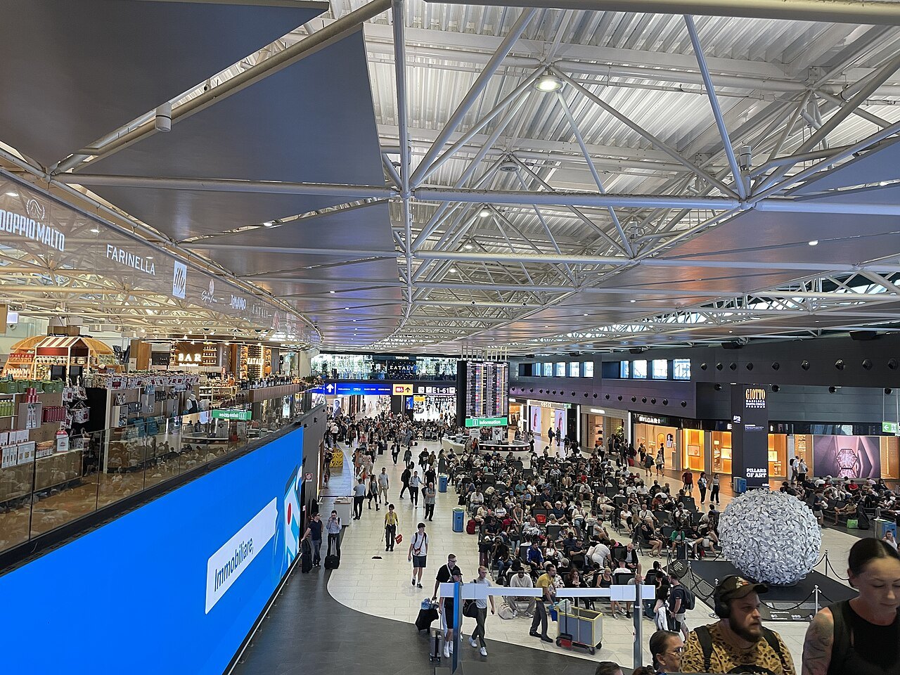 The check-in hall of Terminal 1 at Fiumicino, busy with travelers