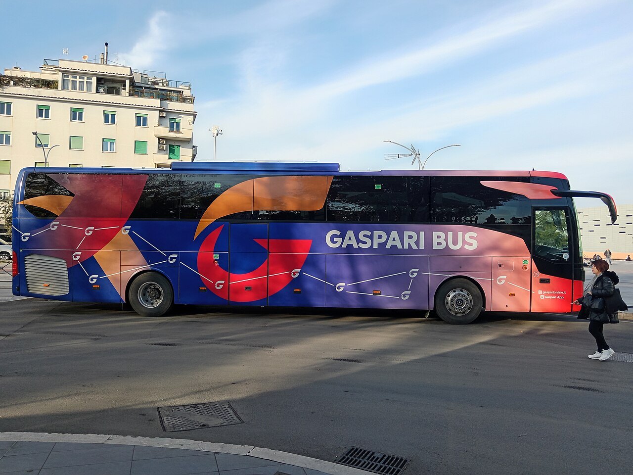 A long-distance coach pulling out in a Rome street