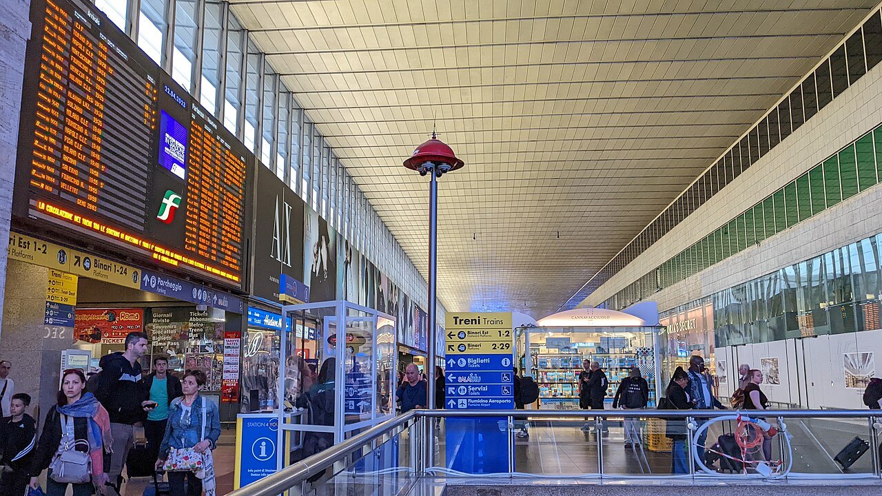 The long main hall of Roma Termini, with departure boards and shops along one side
