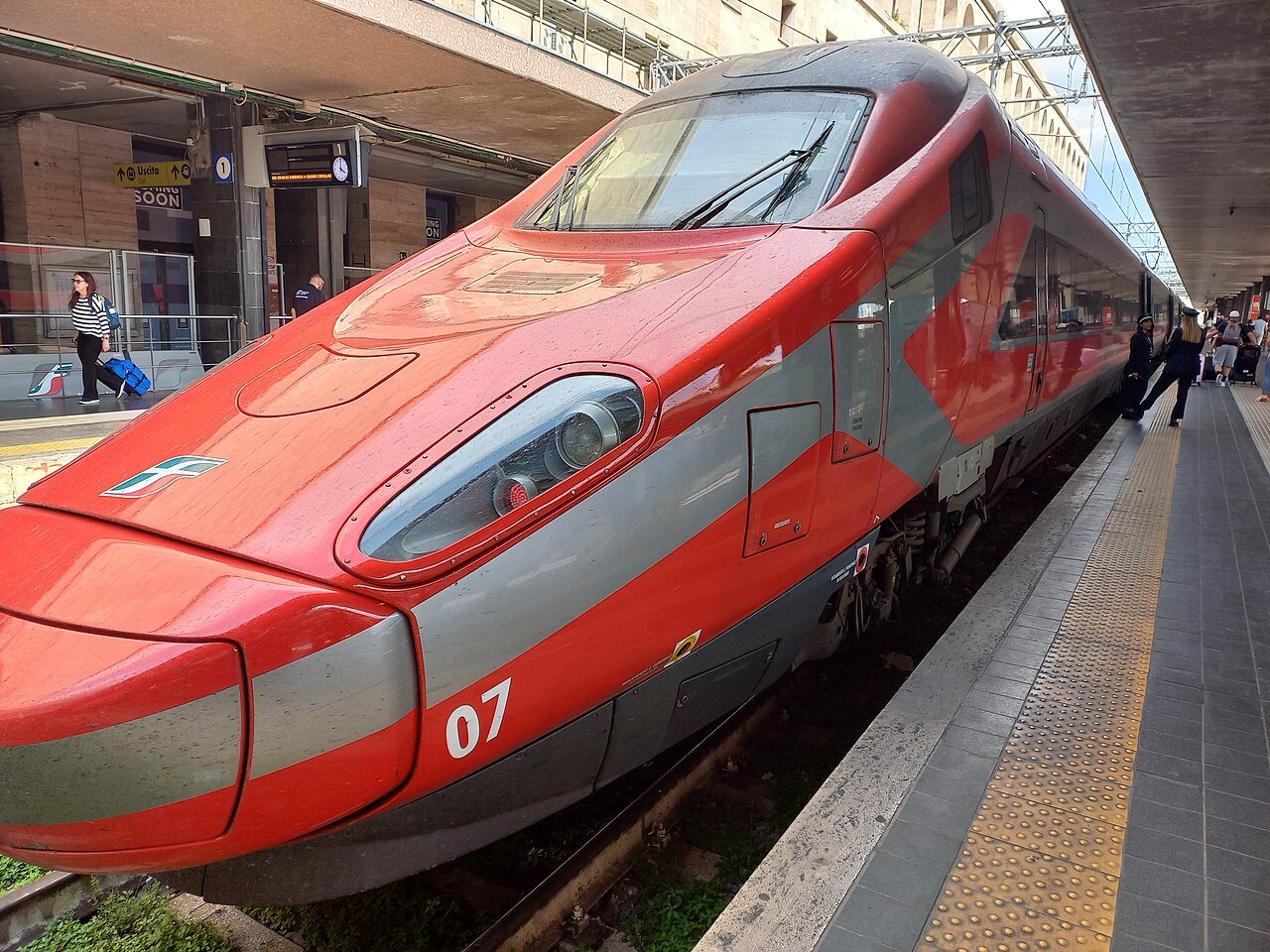 The nose of a red high-speed train at a platform in Rome