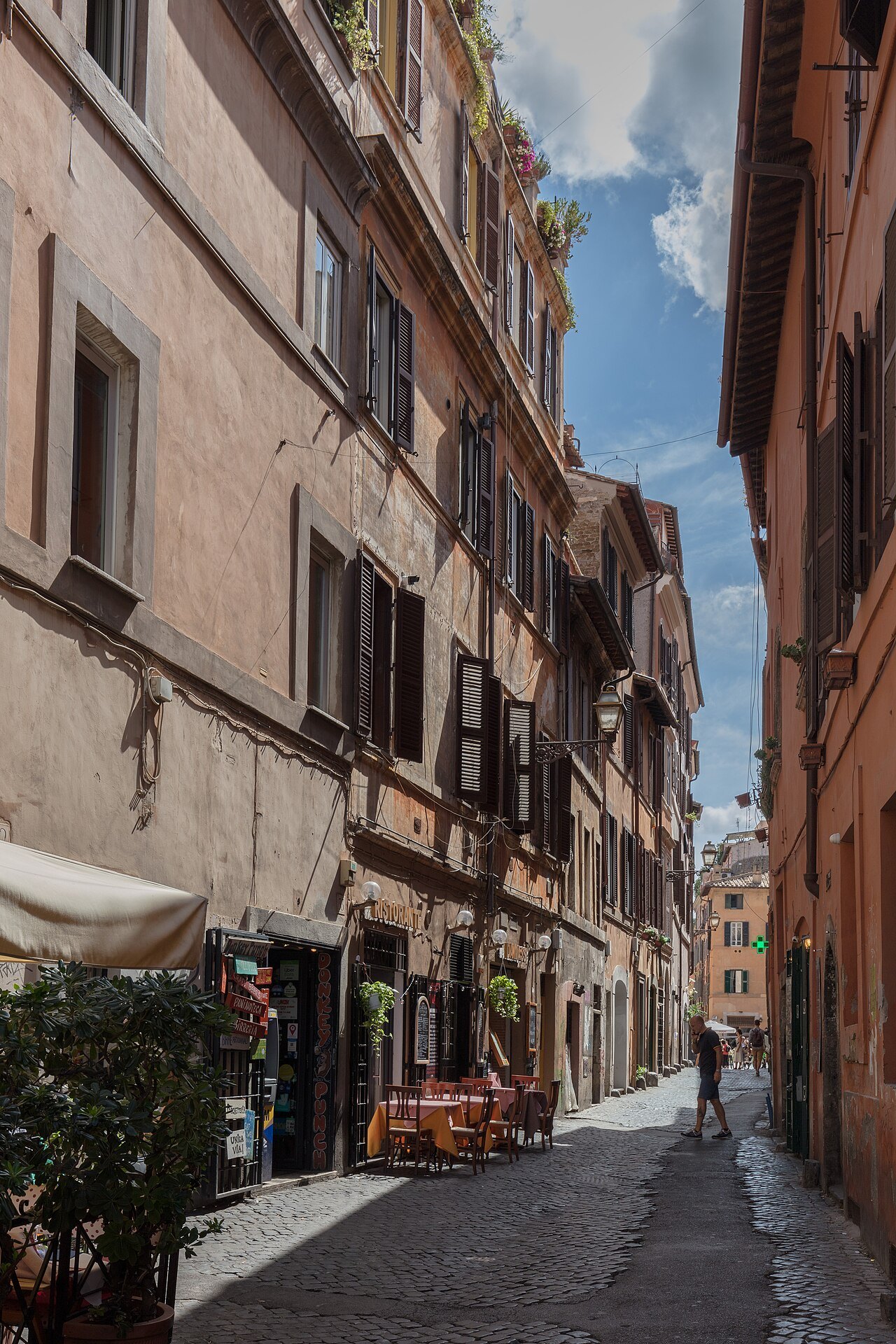 Via della Scala in Trastevere, a narrow street of old houses and restaurant tables