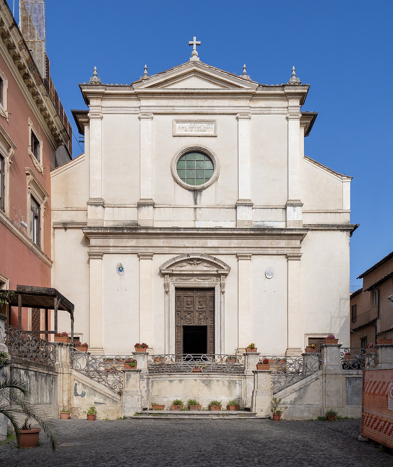 The white façade of San Lorenzo in Panisperna above its courtyard steps