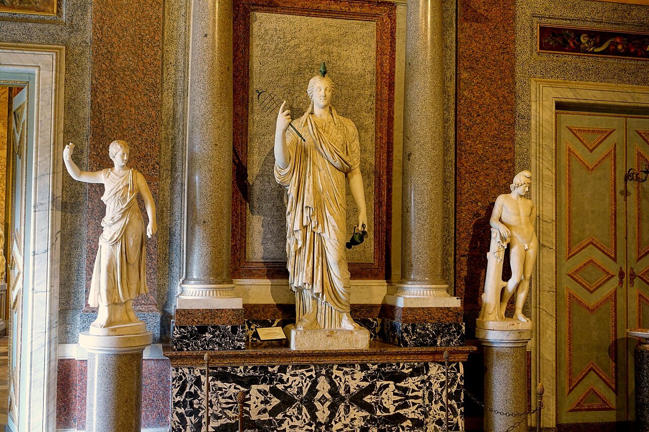 Ancient statues against gilded columns and painted walls in the Egyptian Room of the Borghese Gallery