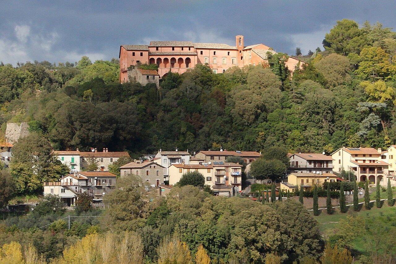 The hill town of Orvieto above woods and houses, its buildings on the edge of the rock