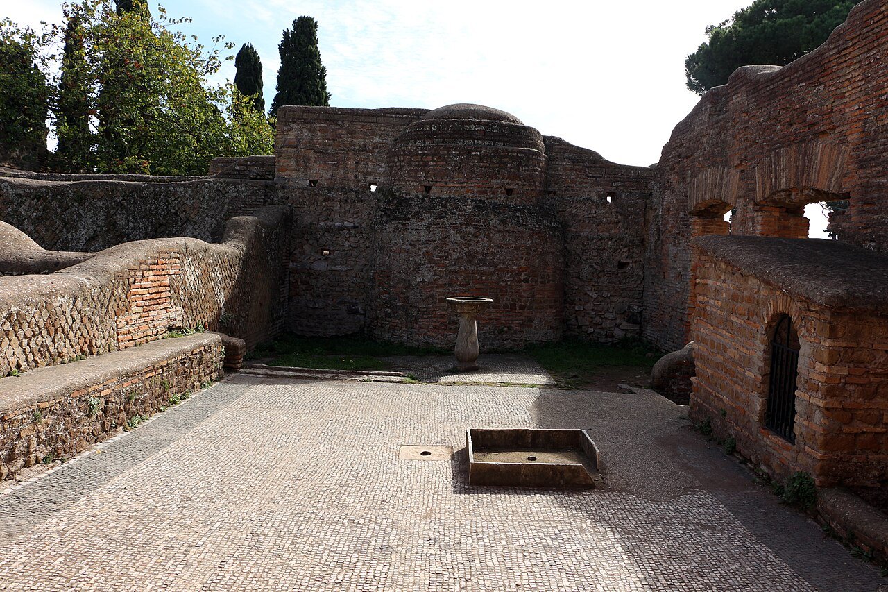A courtyard with a small fountain basin in the ruins of a Roman bar at Ostia Antica