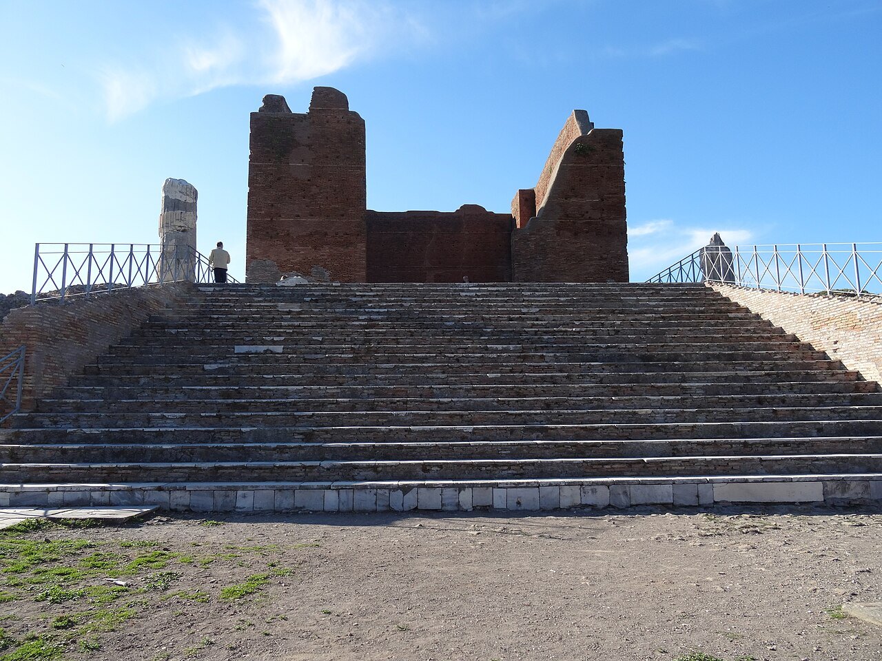 The brick walls of the Capitolium at Ostia Antica above its broad flight of steps