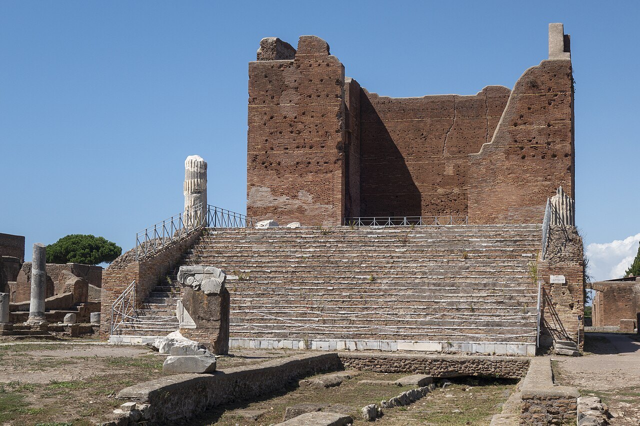 The brick walls and steps of the Capitolium at Ostia Antica against a blue sky