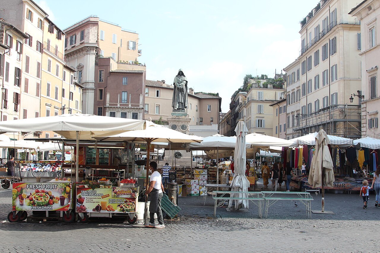 Market umbrellas in Campo de' Fiori below the statue of Giordano Bruno