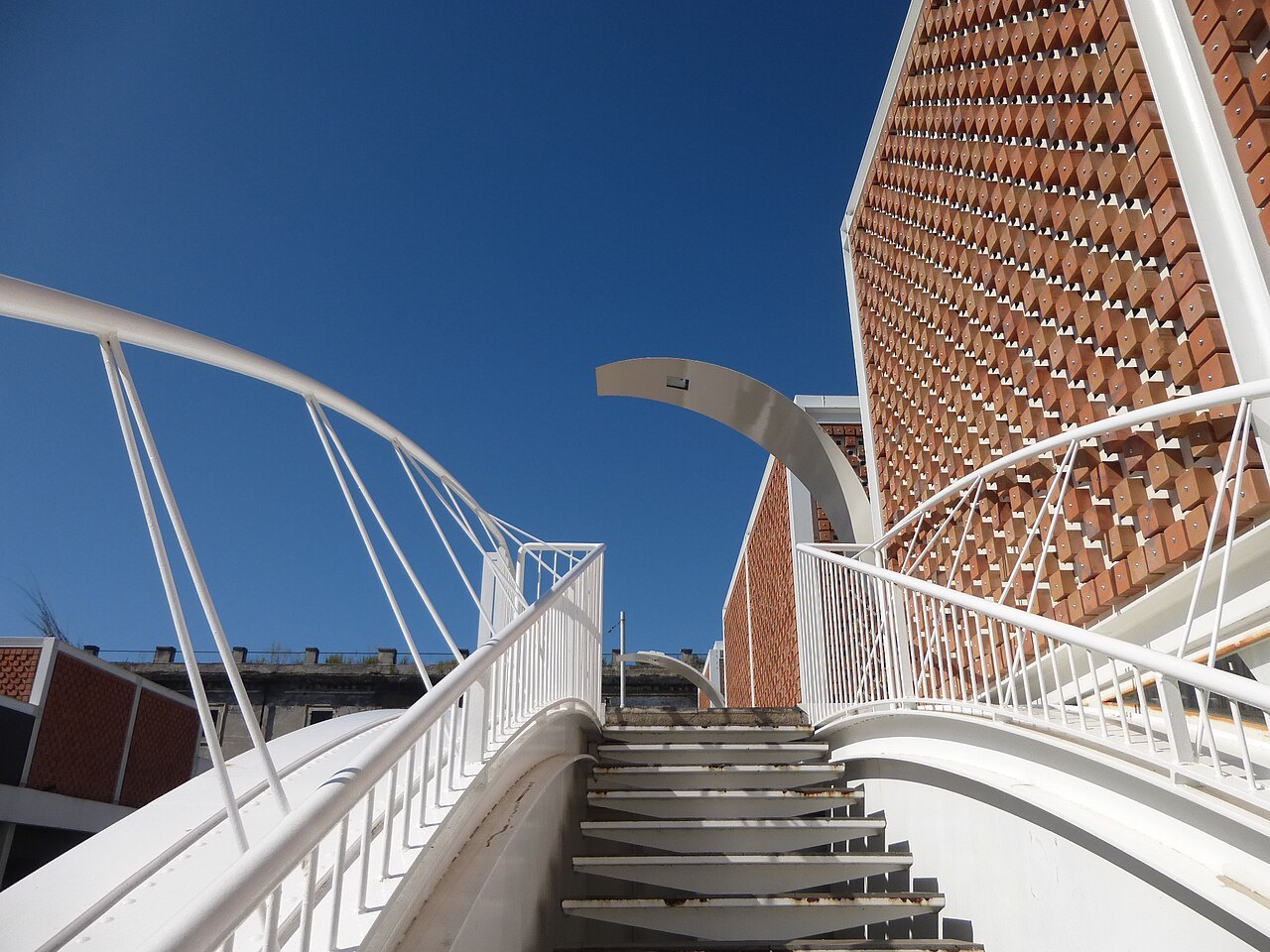 A stair and footbridge between the brick-latticed walls of the Testaccio market