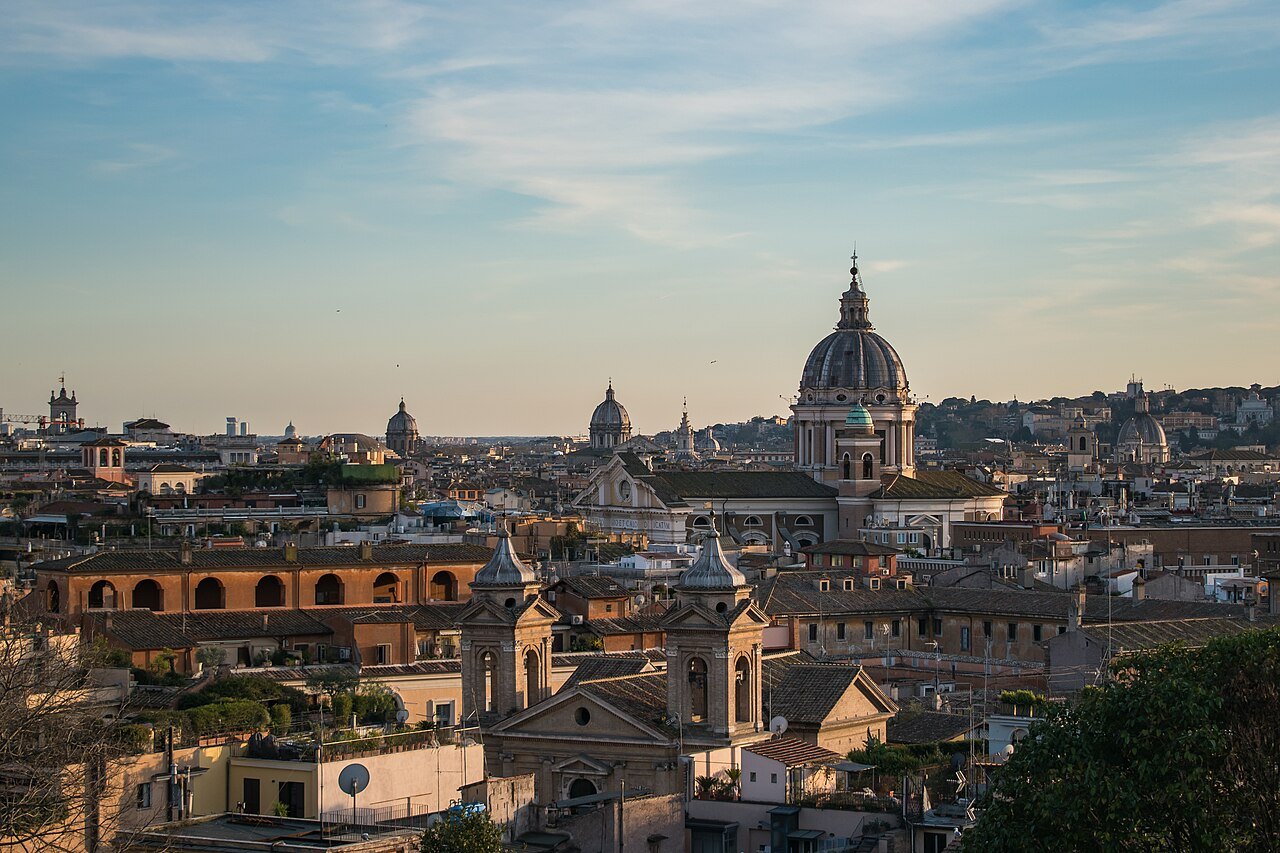 The domes and bell towers of the old center at dusk, seen from a high terrace
