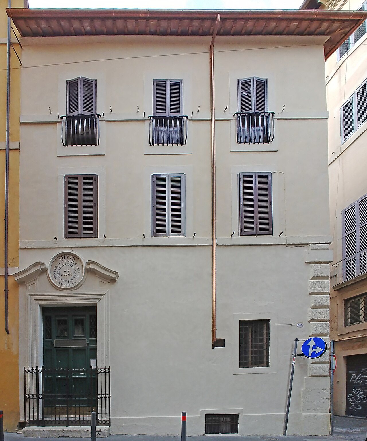 A cream palace front on Via di Torre Argentina, shutters closed over its windows
