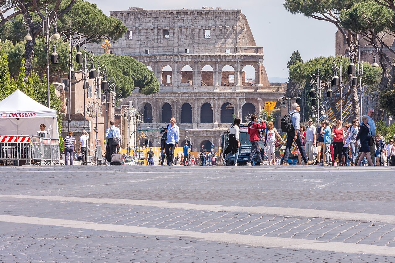 Crowds walking along Via dei Fori Imperiali toward the Colosseum