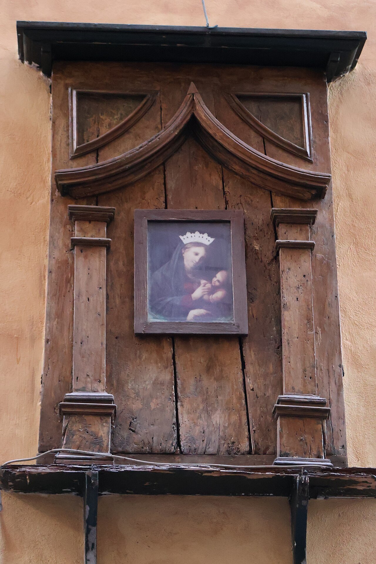 A small shrine of the Madonna in a carved frame on a wall in Via dei Coronari