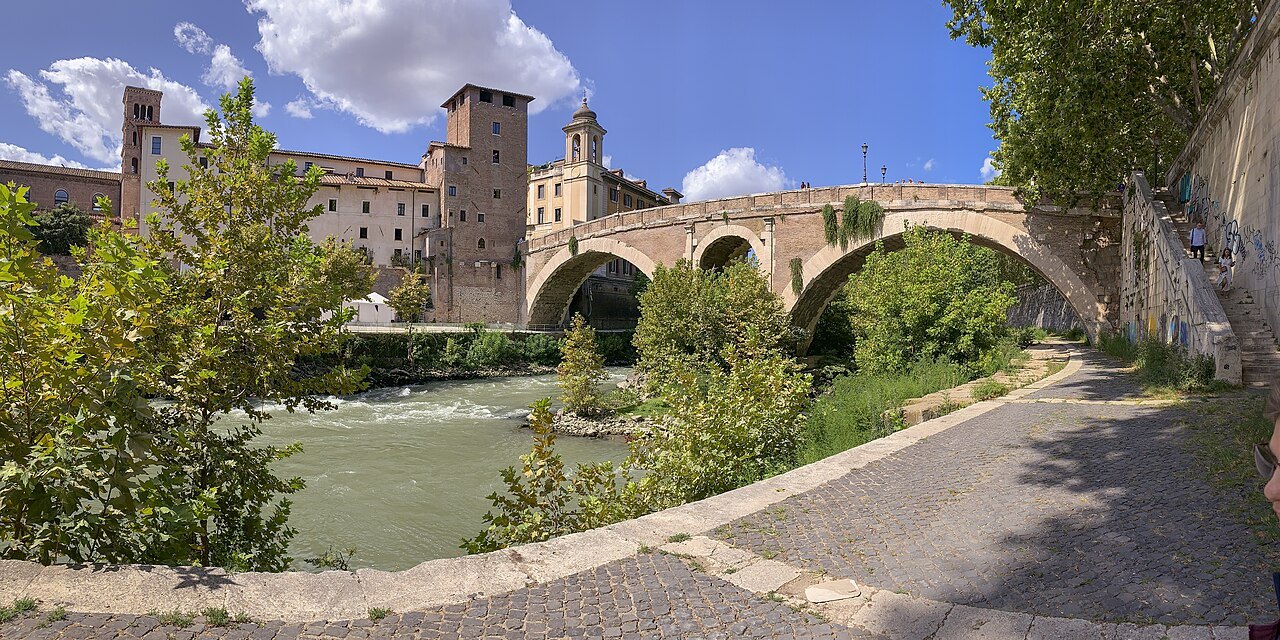 The Tiber Island and the ancient Ponte Fabricio, a riverside path in the foreground