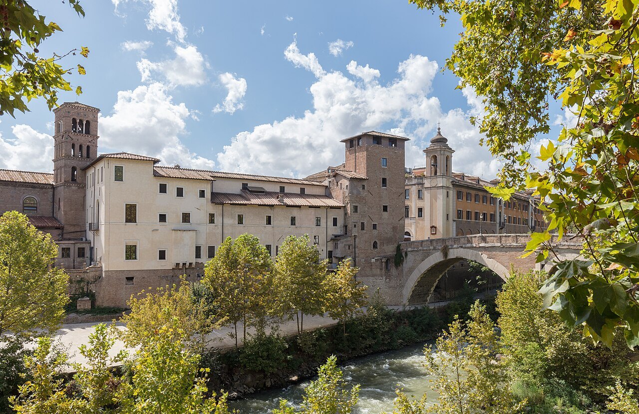 The Tiber Island with its medieval tower and buildings, trees along the river bank