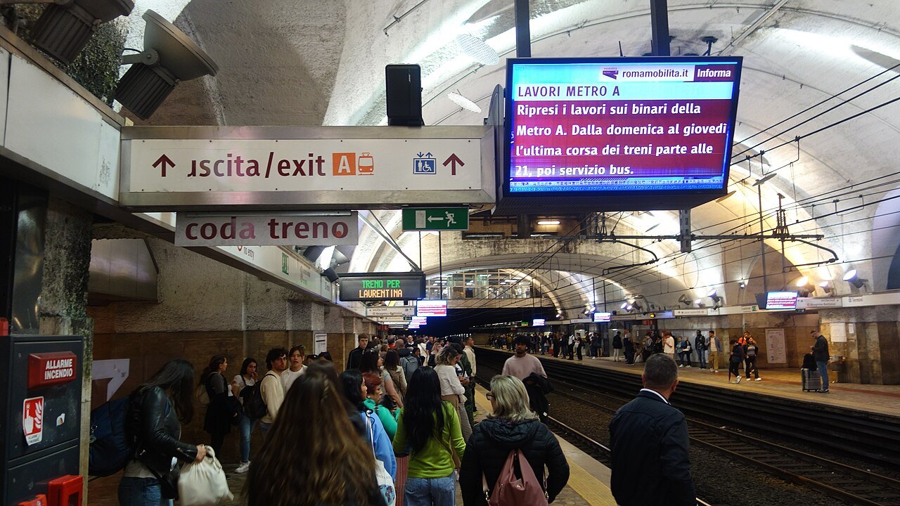A crowded platform at Termini on Metro line B, signs for the exits above