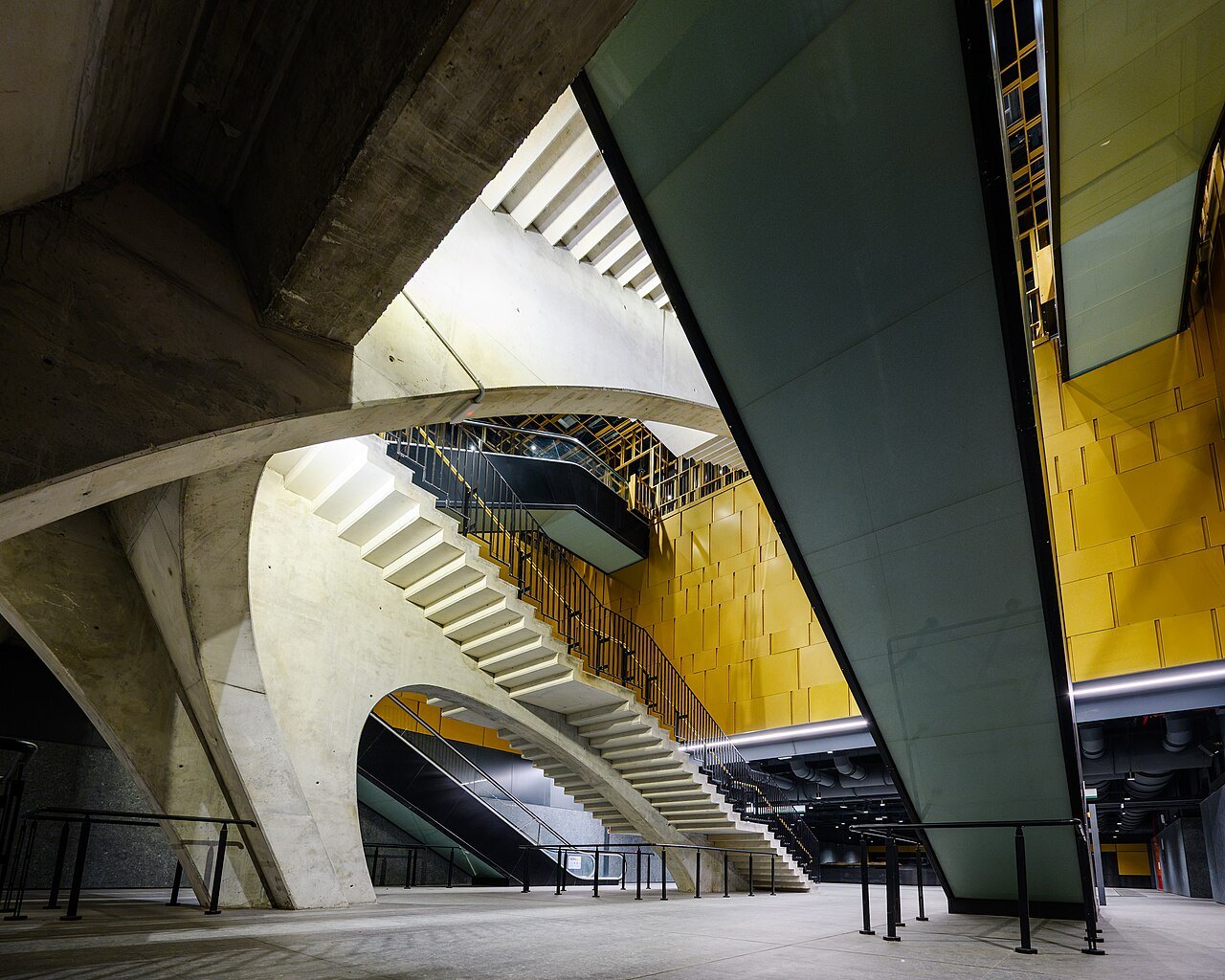Concrete stairs and escalators crossing the deep shaft of Colosseo station on Metro line C