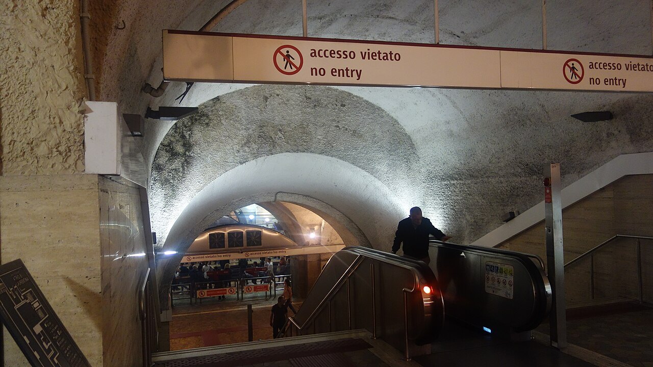 An escalator descending under a vaulted ceiling at the Termini Metro interchange