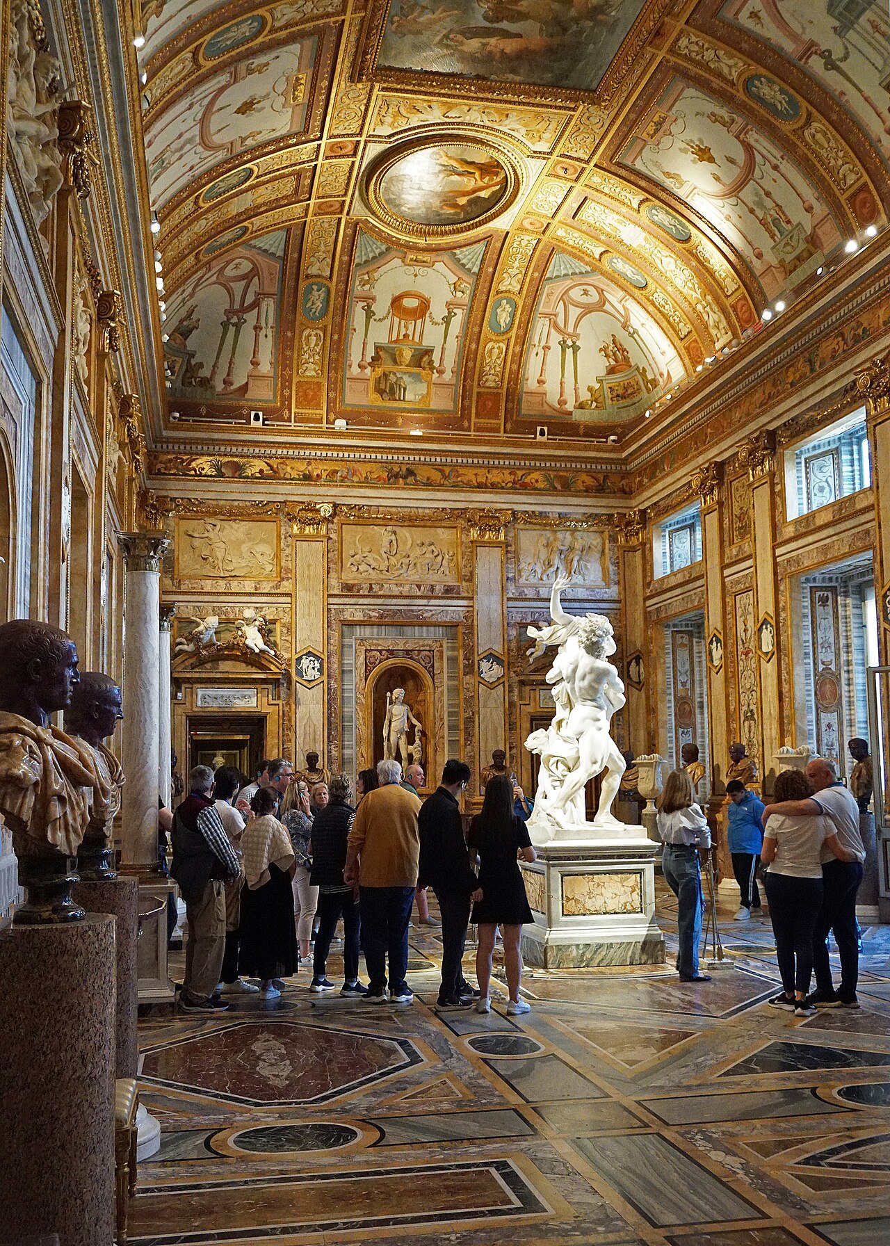 Visitors around Bernini's Pluto and Proserpina in the gilded Room of the Emperors
