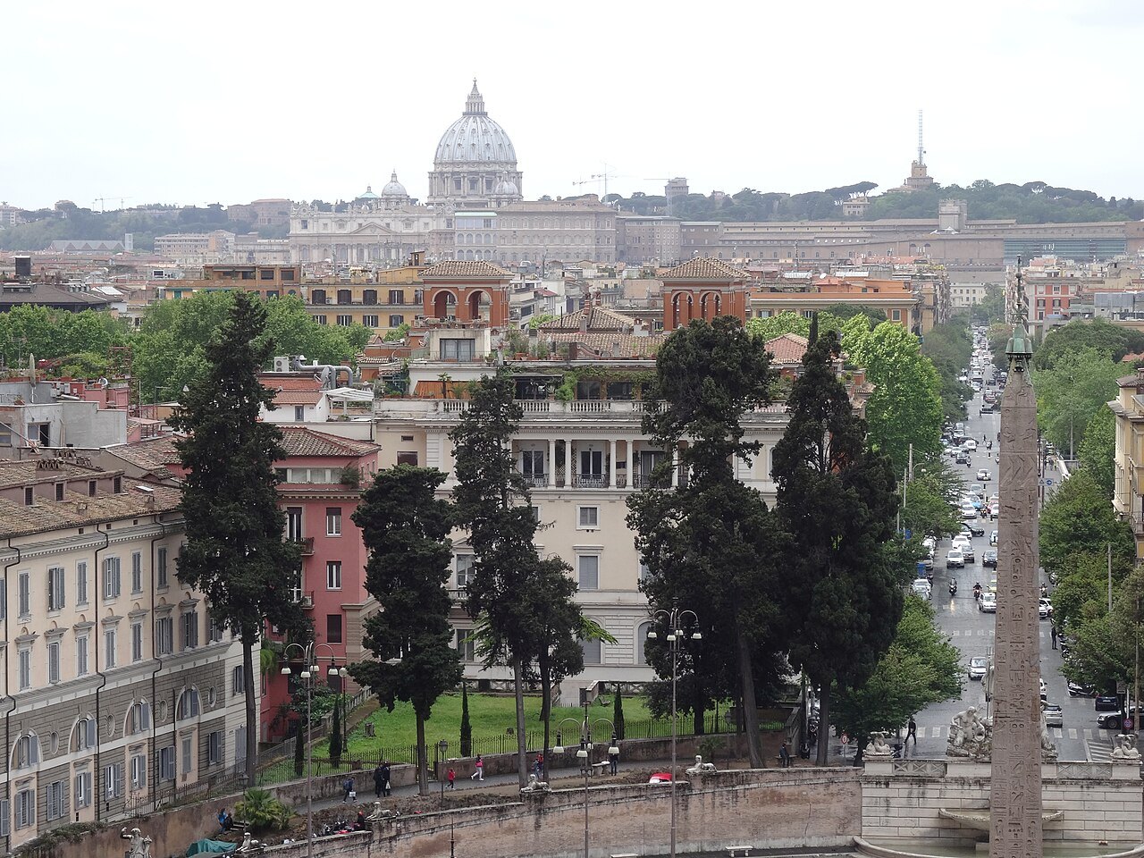 The dome of St. Peter's beyond the trees and rooftops, seen from the Villa Borghese