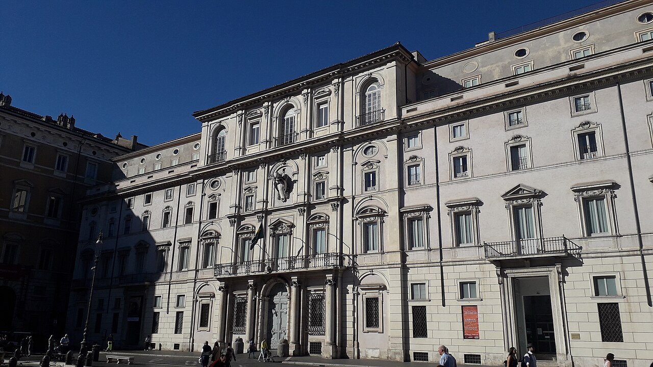 The white façade of Palazzo Pamphilj on Piazza Navona against a deep blue sky