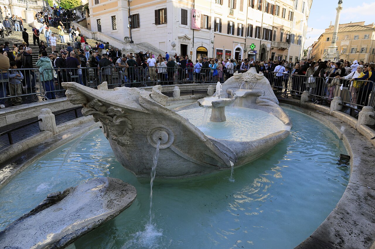 The Barcaccia, the marble boat fountain below the Spanish Steps, crowds on the steps above