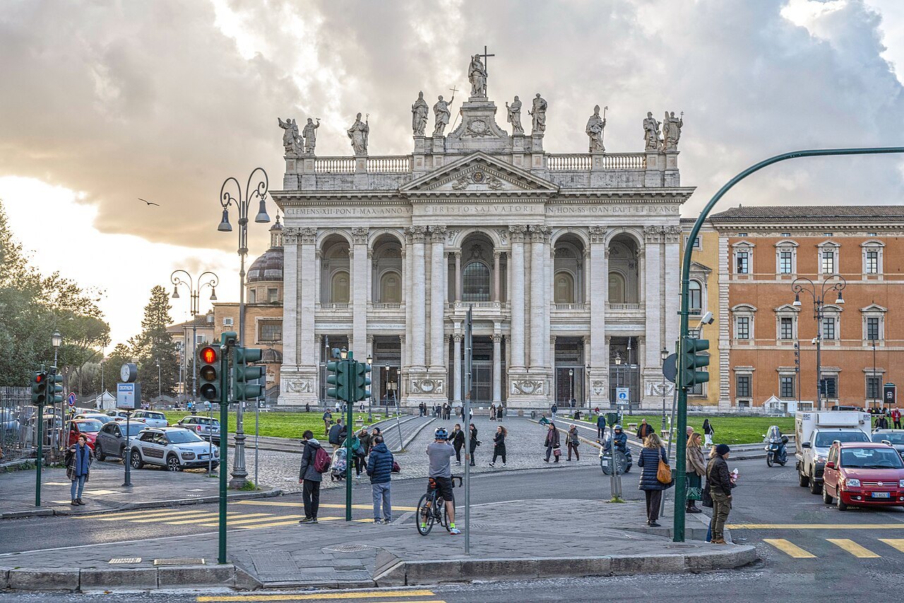 St. John Lateran at the end of its square, traffic lights and cyclists in the foreground