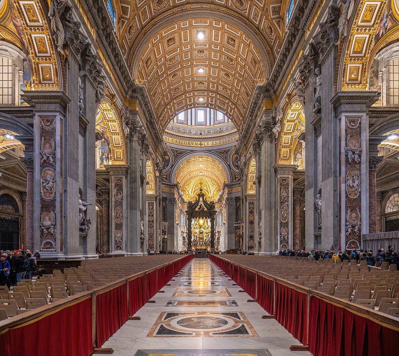 The nave of St. Peter's in low light, gilded coffered vaults over the long central aisle