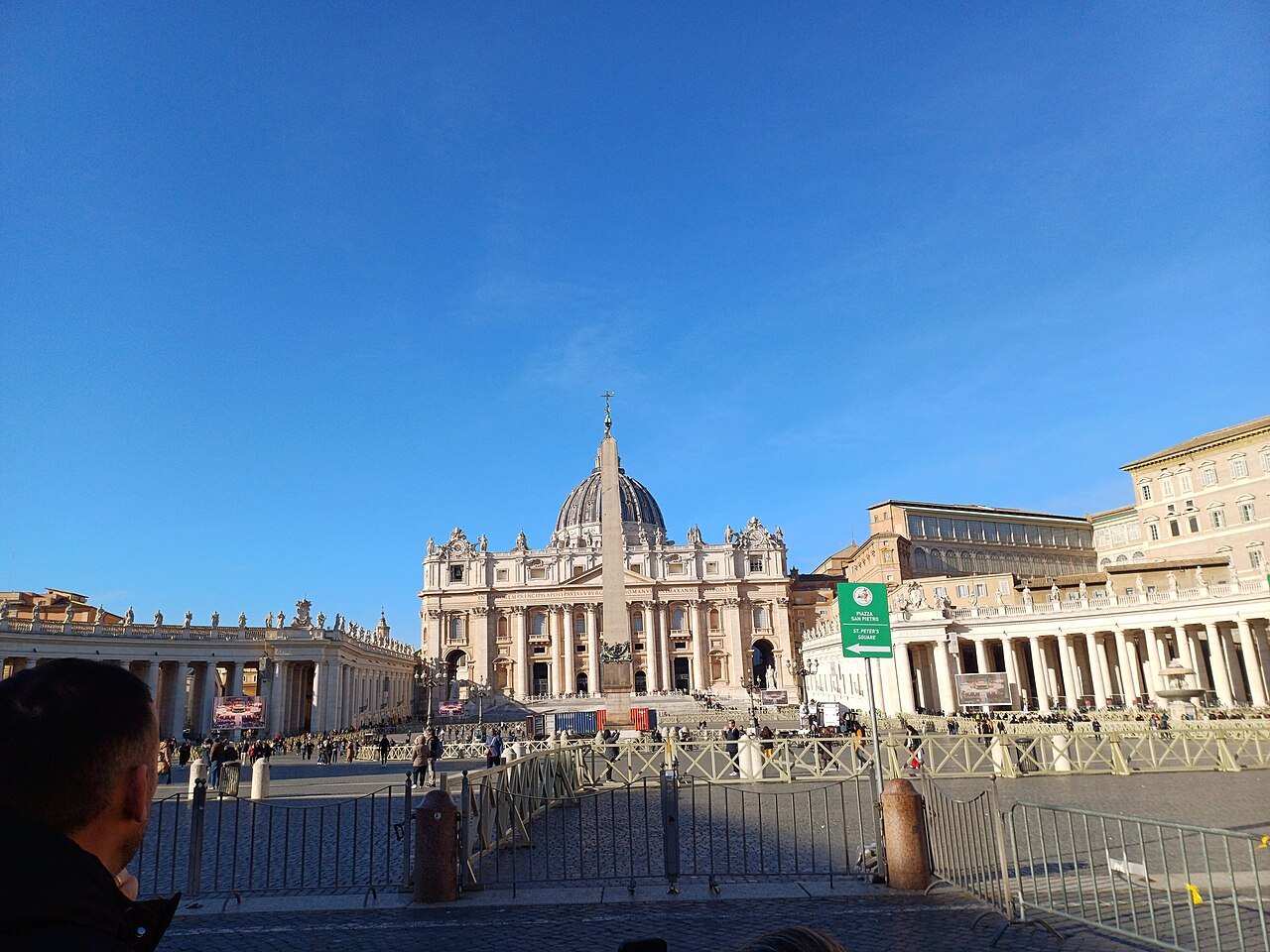 The dome of St. Peter's behind the colonnade and the square on a bright day