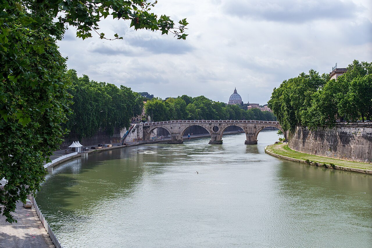 The Tiber between its tree-lined walls, the Ponte Sisto and the dome of St. Peter's beyond