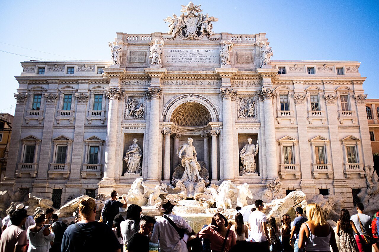 The Trevi Fountain crowded with visitors in bright sunshine