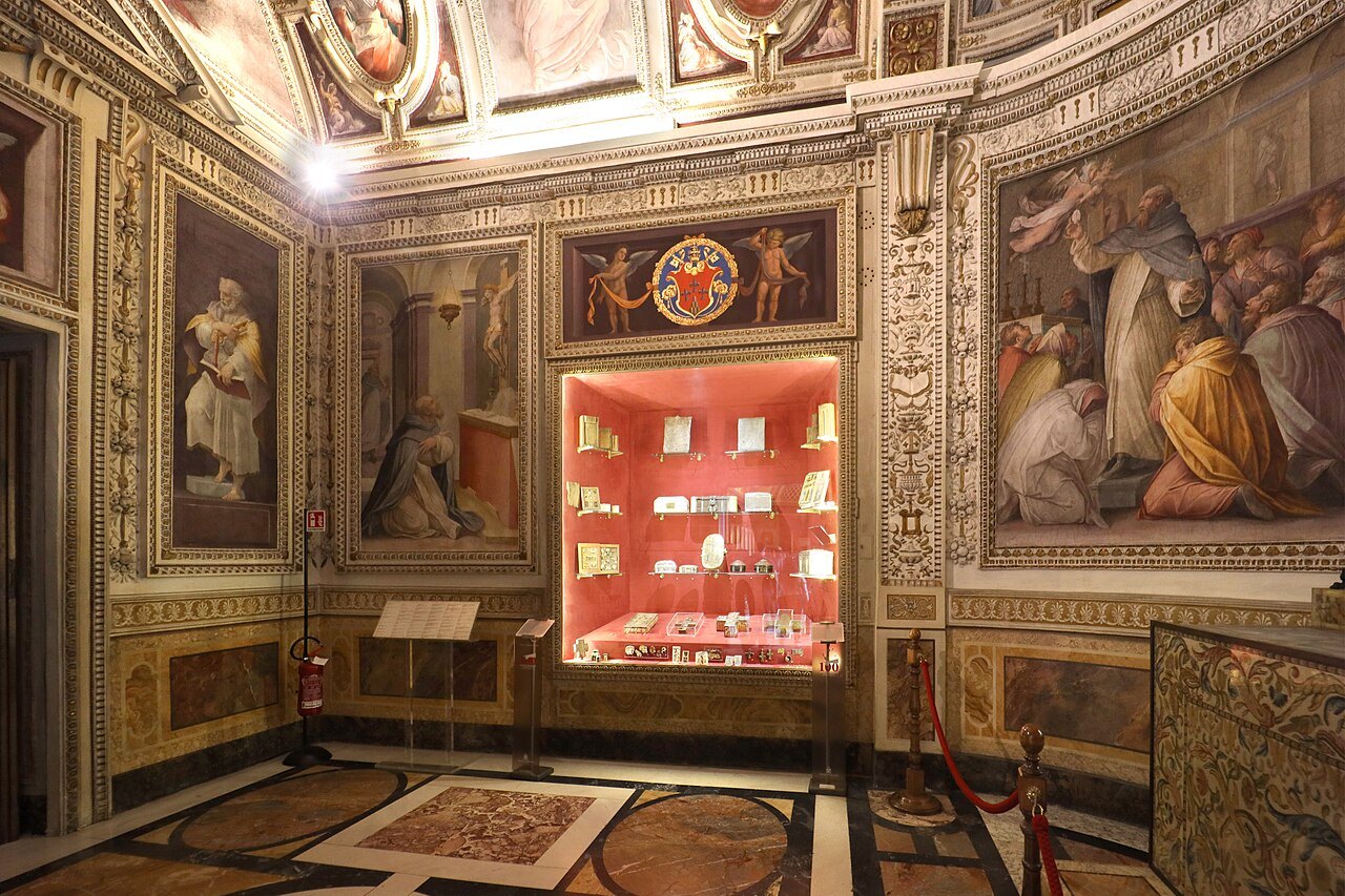 A frescoed chapel in the Vatican Museums, a red-lined display case in the middle