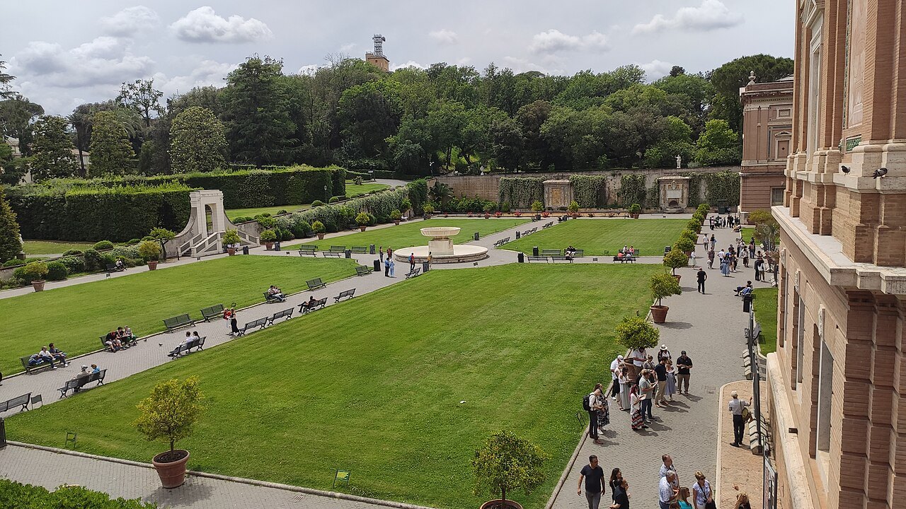 A courtyard of the Vatican Museums laid out as lawns, visitors walking along its paths